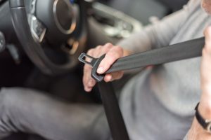 man putting on seat belt