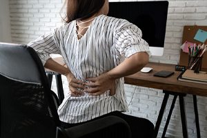 woman back pain desk