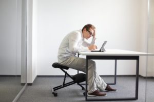 person sitting at a desk with neck pain