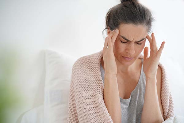 woman with a headache in need of chiropractic treatment in Richardson