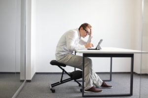 man with bad posture sitting at a computer