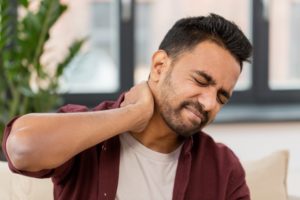 man suffering from chronic neck pain