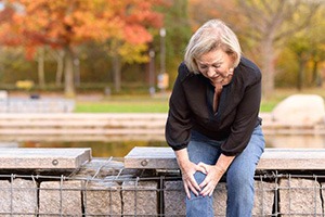 older woman holding her knee in pain