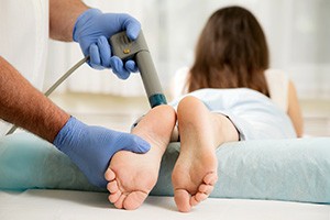 patient getting shockwave therapy on her feet