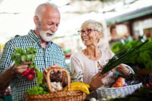 smiling elderly couple buying fresh foods