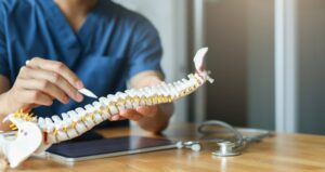 chiropractor pointing at a model spine to talk about decompression