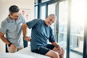 older man showing his chiropractor his back pain