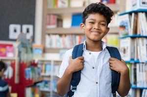 smiling boy at school with a backpack